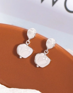 Macro shot of silver irregular geometric earrings with a hand-hammered metal texture