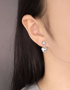 Detail view of silver irregular meteorite earrings on model with high reflective finish