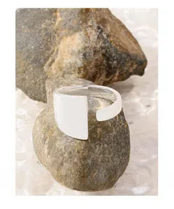 Close-up of S925 sterling silver geometric open ring on a textured natural rock