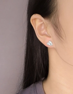 Gros plan sur les boucles d'oreilles cœur en argent S925 avec fini mat texturé