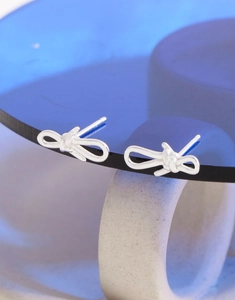 Macro shot of S925 sterling silver bowknot stud earrings with authentic hallmark engraving