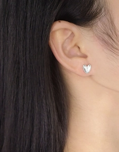 Gros plan de boucles d'oreilles en argent S925 en forme de cœur avec fini martelé