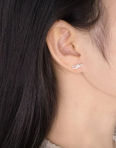 Close-up of S925 sterling silver bow earrings worn by a model in elegant side view