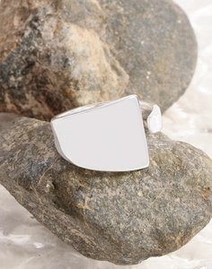Close-up of minimalist S925 silver irregular shield ring on a natural stone surface