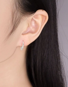 Close-up of minimalist S925 sterling silver hoop earrings worn on a model earlobe