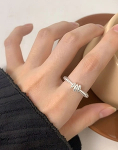 Macro detail of S925 sterling silver triple ring on finger with minimalist wrap design