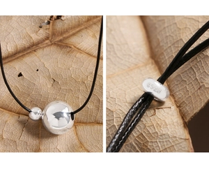 Macro shot of S925 sterling silver stamp on minimalist ball pendant necklace detail
