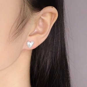 Boucles d'oreilles cœur en argent S925 avec texture martelée portées par un mannequin