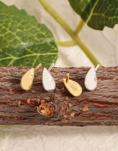 Vue macro de boucles d'oreilles gouttes d'eau en argent S925 finitions or et argent