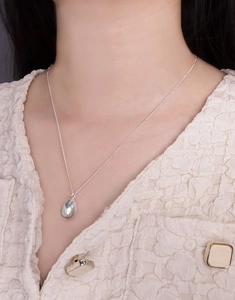 Close-up of a minimalist S925 sterling silver waterdrop pendant necklace on a model