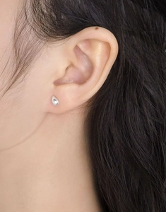 Gros plan d'une boucle d'oreille goutte en argent sur modèle au fini poli brillant