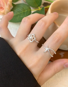 Detail of silver S925 starfish ring and flower ring with pearl on hand