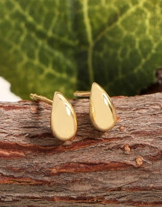 Gros plan du poinçon S925 sur boucles d'oreilles gouttes dorées sur bois naturel