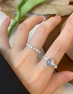 Close-up of S925 silver textured band and lavender gemstone ring on female hand