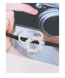 Macro shot of silver floral ring with textured lava-like finish and open adjustable band