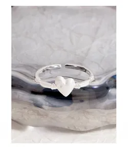 Detailed macro of S925 sterling silver matte heart ring with a small diamond on glass