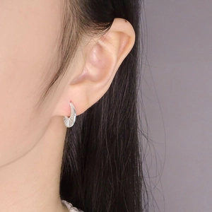 S925 sterling silver hoop earrings with sunburst texture worn by a model in a side view