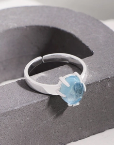 Macro shot of oval aquamarine stone in four-prong setting on S925 sterling silver ring