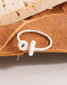Close-up of S925 sterling silver minimalist open ring with bead and bar on a leaf
