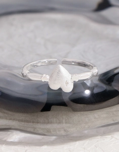 Macro view of matte S925 silver heart ring featuring star engraving and textured band