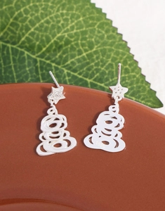 Close-up of S925 sterling silver star earrings with zircons hanging on a ceramic pot