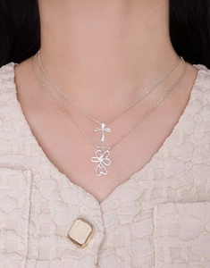 Detail of S925 sterling silver layered necklace with cross and hollow flower pendants
