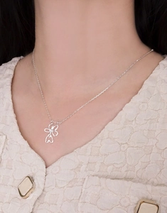 Close-up of S925 sterling silver four-leaf clover heart pendant necklace on a model
