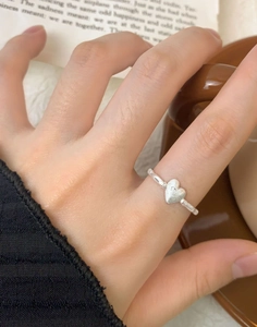 Close-up of S925 sterling silver ring featuring a matte heart design worn on a finger