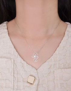 Detail shot of S925 sterling silver four-petal flower pendant necklace on a model's neck