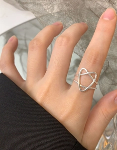 Nahaufnahme eines minimalistischen S925 Silberrings mit hohlem Herz und Dreiecksgeometrie