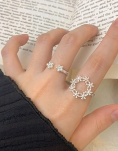 Detail of S925 sterling silver floral rings on fingers with literary book background
