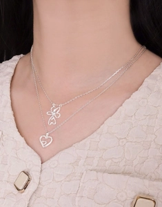 Detail of silver S925 double-layer necklace with hollow flower and heart pendants