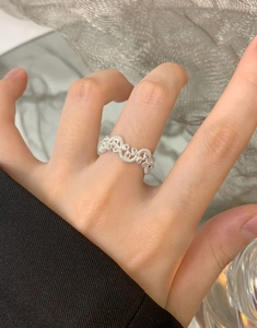 Close-up of S925 sterling silver woven ring with intricate twisted design on model's finger