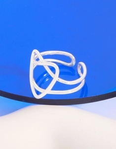 Makroaufnahme eines silbernen hohlen geometrischen Herzrings auf blauem Display