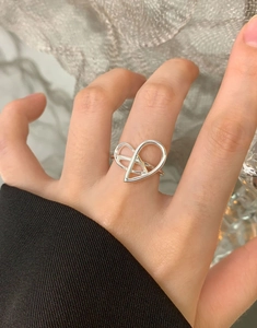 Detail shot of a silver heart-shaped hollow ring with geometric openwork design