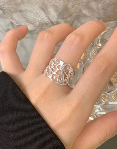Vue détaillée d'une bague large en argent S925 ajourée avec motifs de volutes rétro