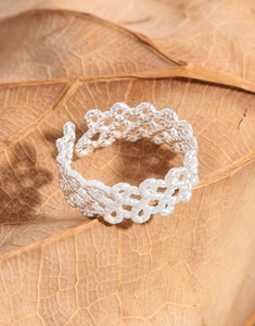 Detailed view of the S925 silver woven lace mesh hollow ring on a natural leaf background