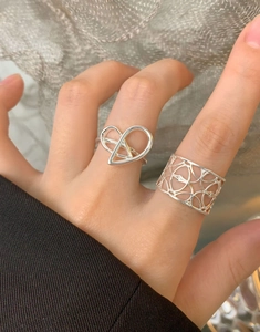 Dettaglio dell'anello in argento S925 con design a maglia vuota e motivi a cuore