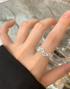 Detail view of S925 silver irregular woven twisted ring on finger with polished finish
