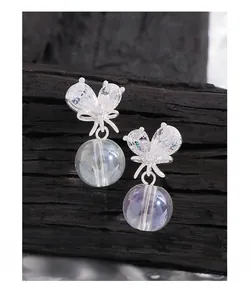 Détail de boucles d'oreilles nœud en argent avec zircons et perle translucide
