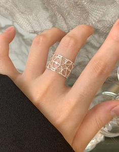 Dettaglio di un anello largo traforato in argento S925 con design geometrico al dito