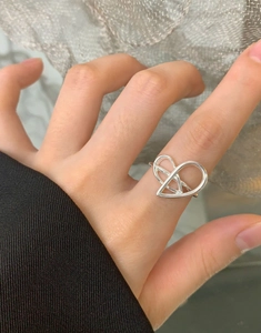 Close-up of a minimalist silver hollow heart ring featuring a double-line geometric design