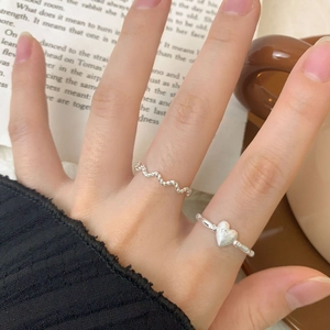 Matte silver heart and wavy stackable ring set for women on model hand in cozy setting