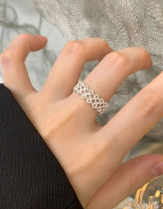 Detailed macro view of S925 sterling silver woven lace ring texture on a finger