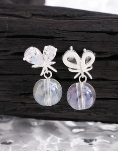 Vue macro de boucles d'oreilles nœud en argent S925 avec zircon et perles de cristal