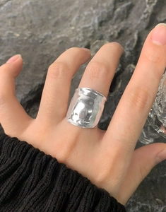 Close-up of wide S925 silver ring with hammered foil texture on female finger