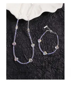 Close-up of S925 silver heart crystal bead necklace and bracelet set on black paper
