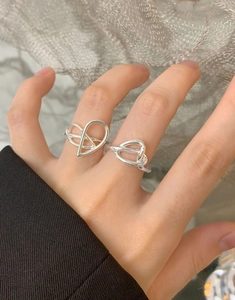 Detail showing irregular heart and knot S925 silver rings worn on fingers