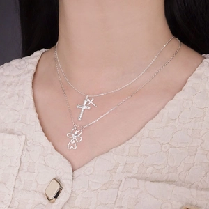 Silver 925 double layered necklace featuring cross and cutout flower charms on a model