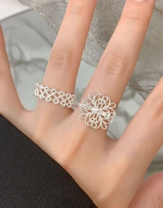 Close-up of S925 sterling silver hollow floral rings with intricate lace pattern detail